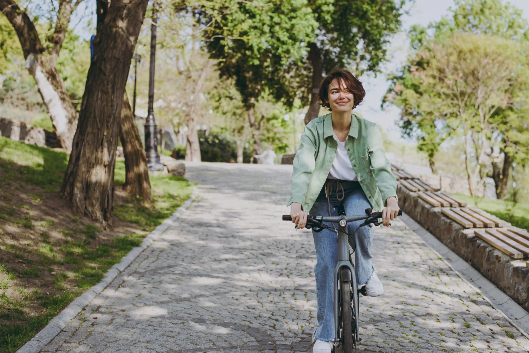 Young woman riding a bike through a park