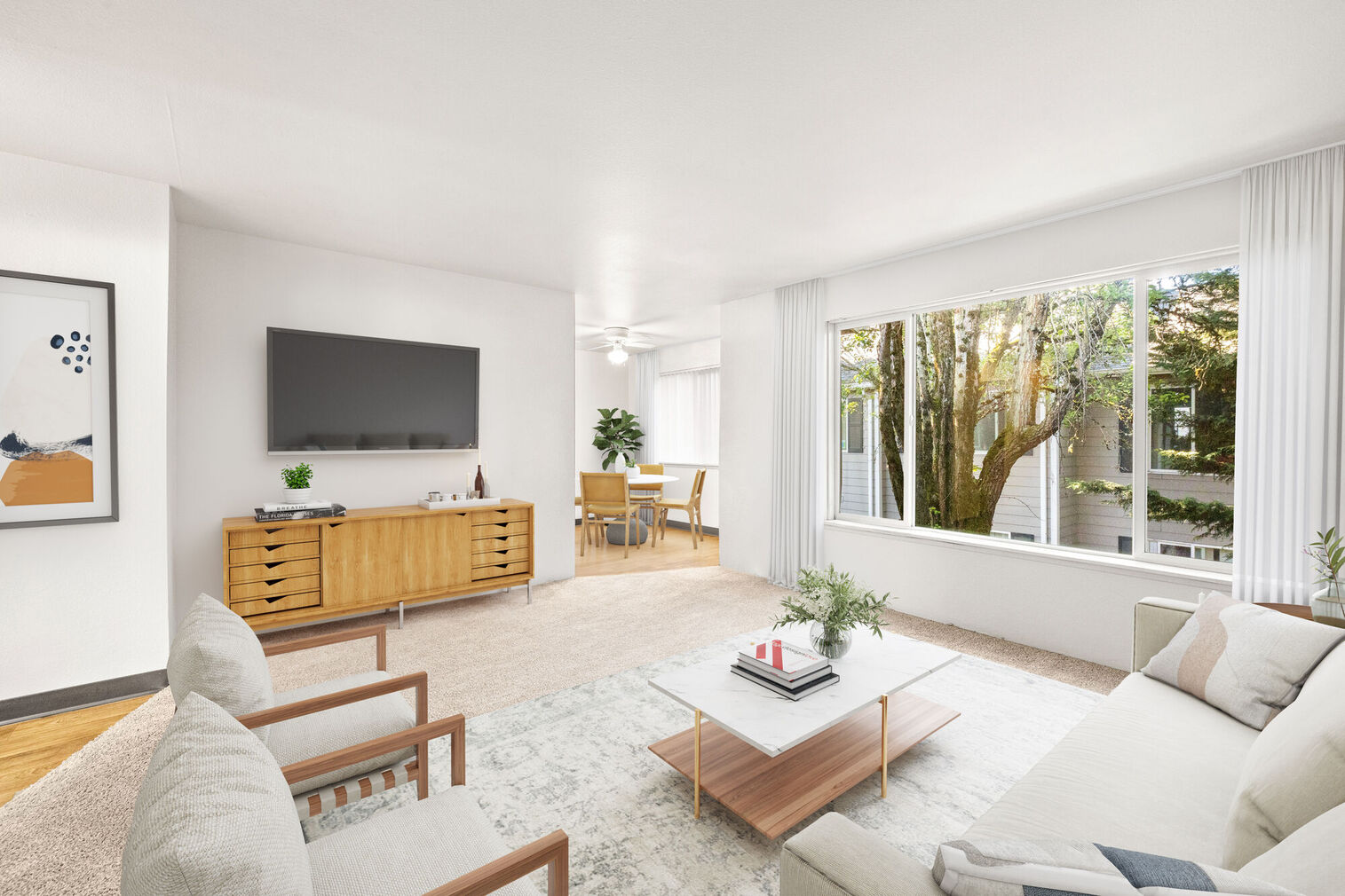 Open living room with large windows and view into the dining room