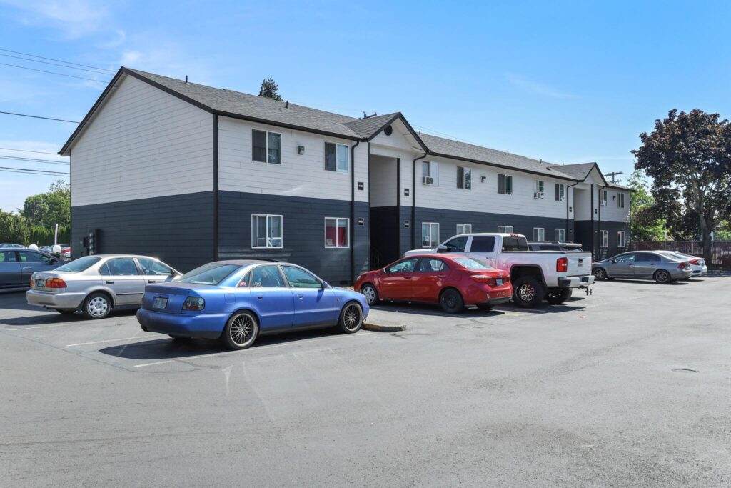 Exterior of a two-story apartment building with a dark blue and white painting.